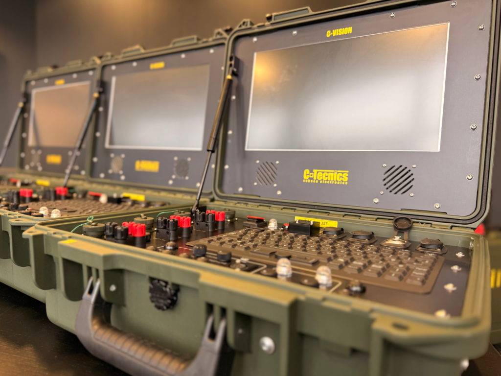 Multiple C-Vision Encrypt control units opened and arranged in sequence, displaying screens and control panels ready for deployment.