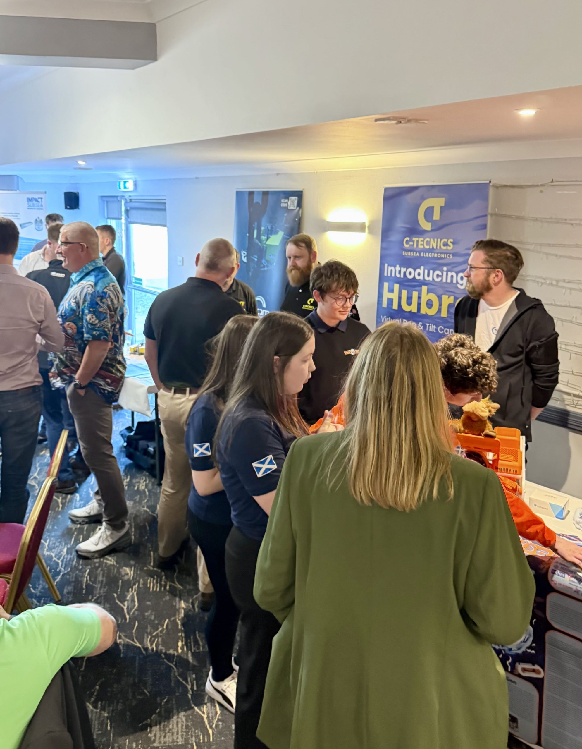Attendees speaking at the C-Tecnics Hubro stand during SUT Gadgets and Widgets 2026.